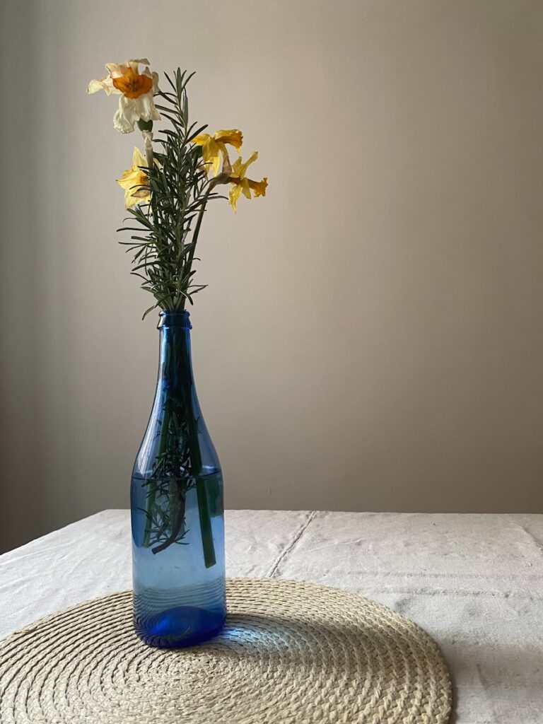a blue vase filled with yellow and white flowers